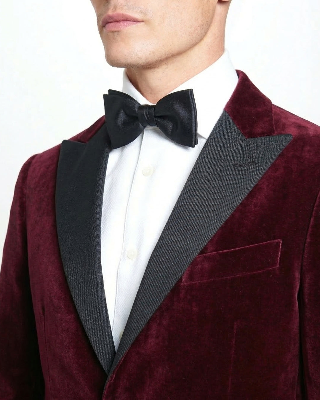 Chaqueta de gala en terciopelo granate con solapa de pico y corte entallado.